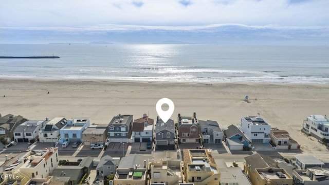 drone / aerial view with a residential view, a water view, and a beach view