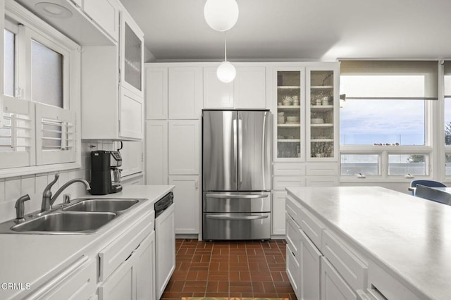 kitchen with a sink, white cabinetry, light countertops, and freestanding refrigerator