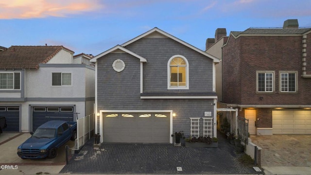 view of front of property with a garage, decorative driveway, and a chimney