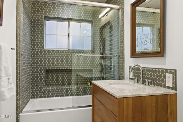 bathroom featuring vanity and shower / bath combination with glass door