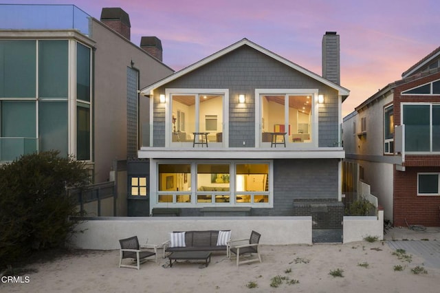 back of property featuring a patio, a chimney, and a balcony