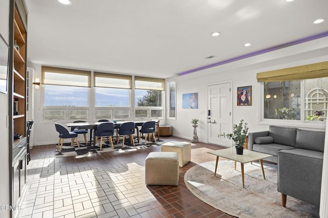 living area featuring recessed lighting, baseboards, and brick floor