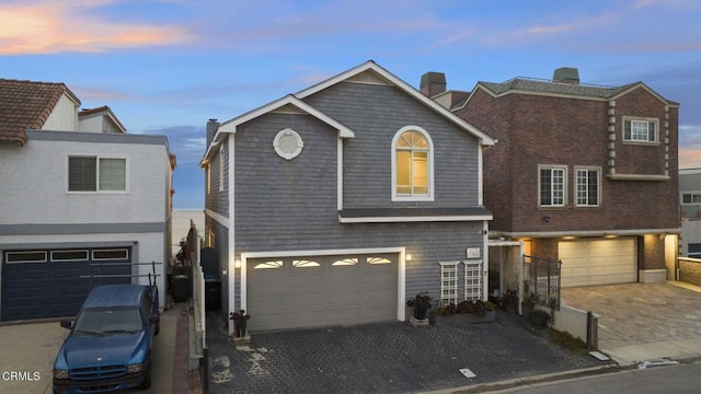 traditional home featuring driveway, a chimney, and a garage