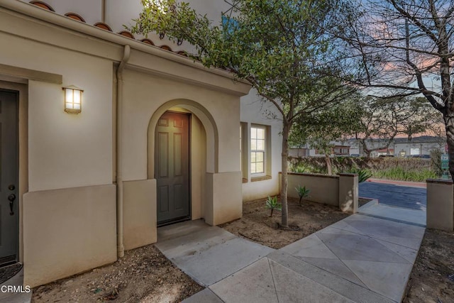 exterior entry at dusk with stucco siding