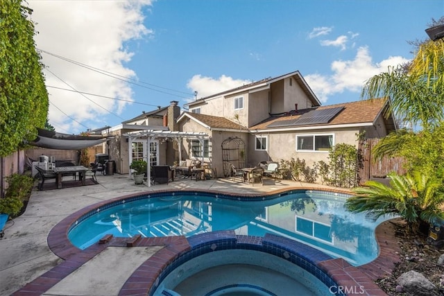 view of pool with a pool with connected hot tub, fence, a patio, and a pergola