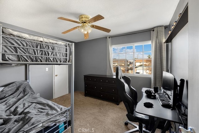 bedroom with carpet flooring, a ceiling fan, and a textured ceiling