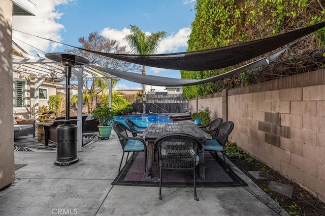 view of patio / terrace featuring outdoor dining space, a fenced backyard, and a fenced in pool