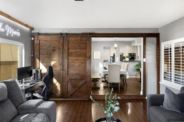 living area with a barn door and wood finished floors