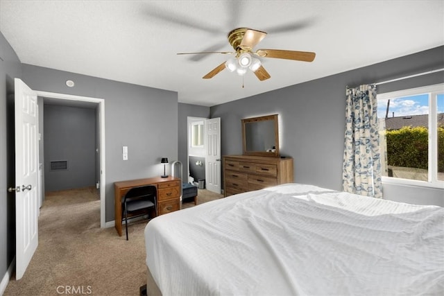 bedroom featuring baseboards, light colored carpet, visible vents, and ceiling fan