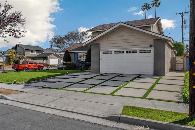 view of front of house featuring a front lawn, brick siding, an attached garage, and driveway