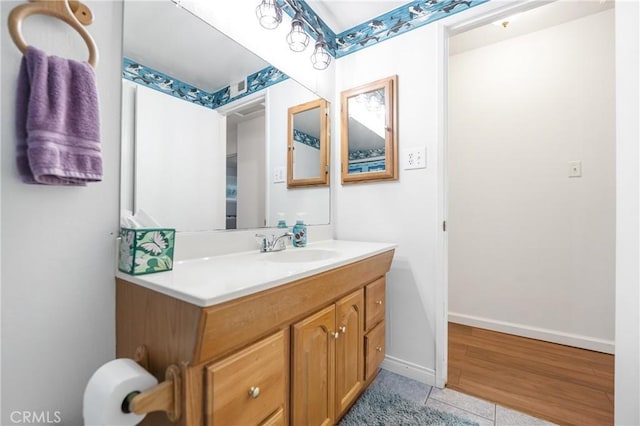 bathroom with baseboards, vanity, and tile patterned flooring