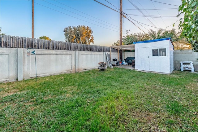 view of yard featuring an outdoor structure, a storage unit, and a fenced backyard