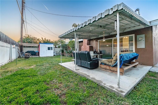 exterior space featuring an outbuilding, a shed, a patio, and a fenced backyard