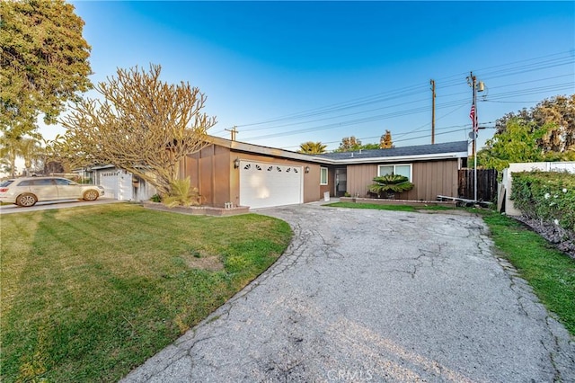 single story home featuring aphalt driveway, a front lawn, a garage, and fence