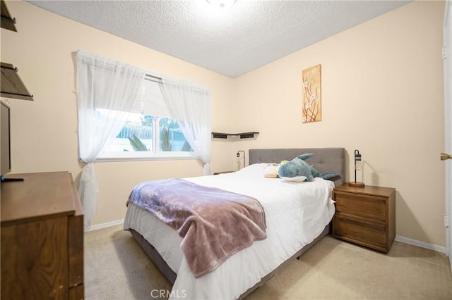 carpeted bedroom featuring baseboards and a textured ceiling