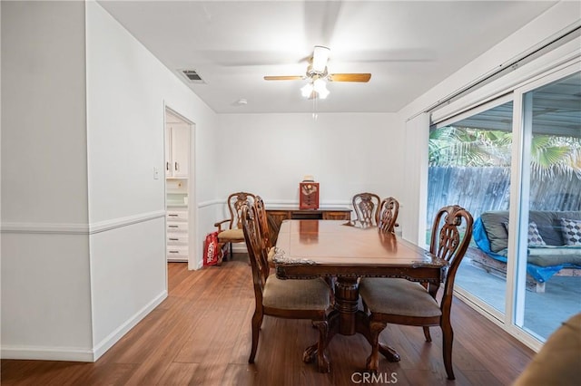 dining space featuring visible vents, baseboards, wood finished floors, and a ceiling fan