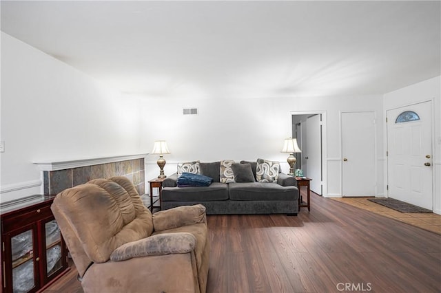 living area with visible vents and wood finished floors