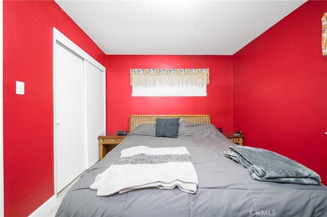 bedroom with a closet, a textured ceiling, and an accent wall