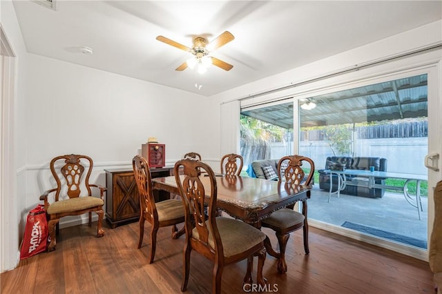 dining room with dark wood-style floors, ceiling fan, and a sunroom