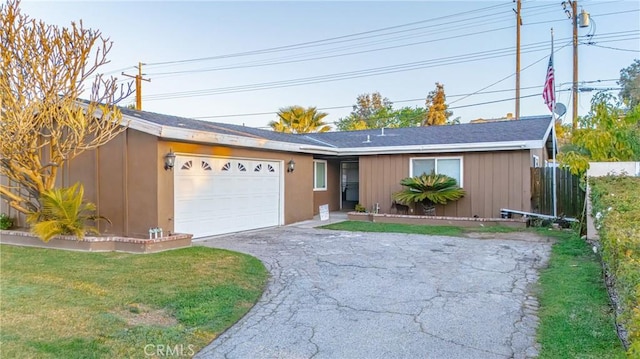 ranch-style house with an attached garage, driveway, a front lawn, and fence