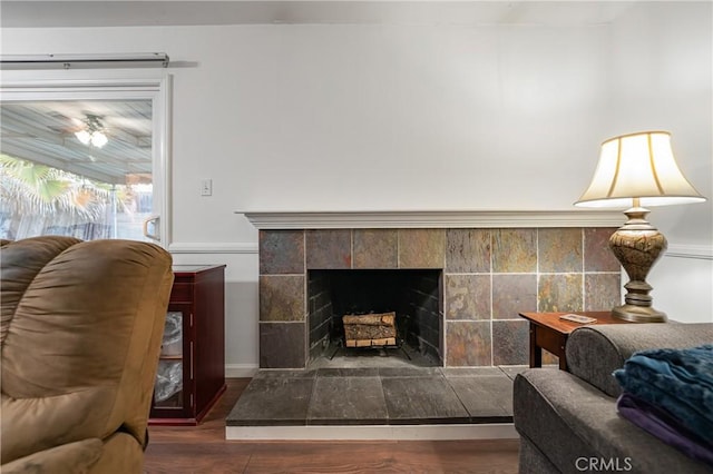 living room with wood finished floors and a tile fireplace