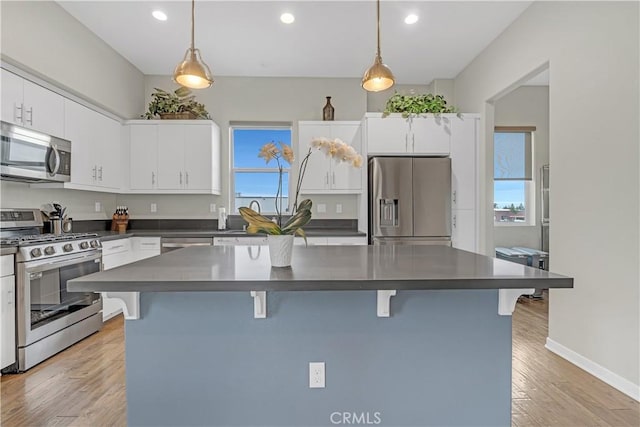 kitchen featuring a breakfast bar, dark countertops, and stainless steel appliances