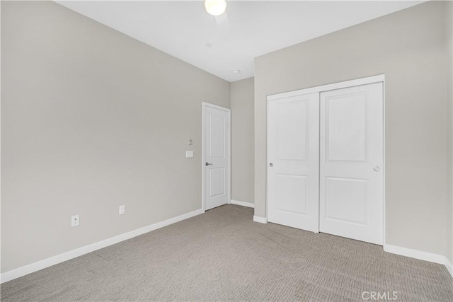 unfurnished bedroom with a closet, baseboards, and carpet