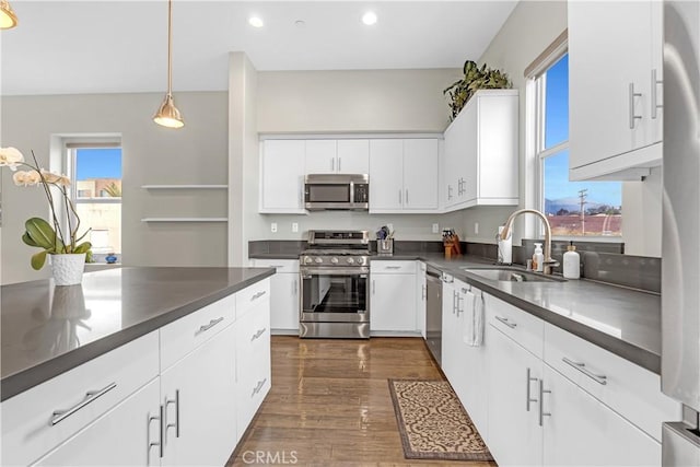 kitchen featuring dark countertops, stainless steel appliances, and a sink