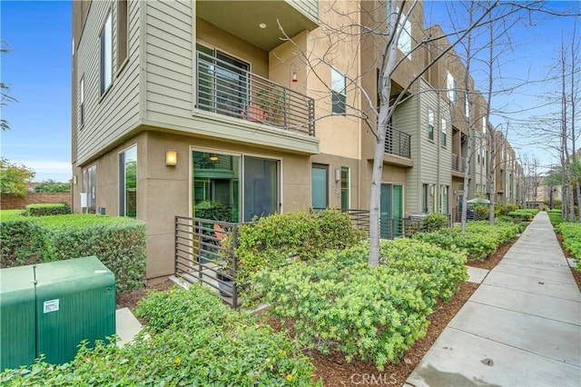 view of property exterior featuring stucco siding and a balcony