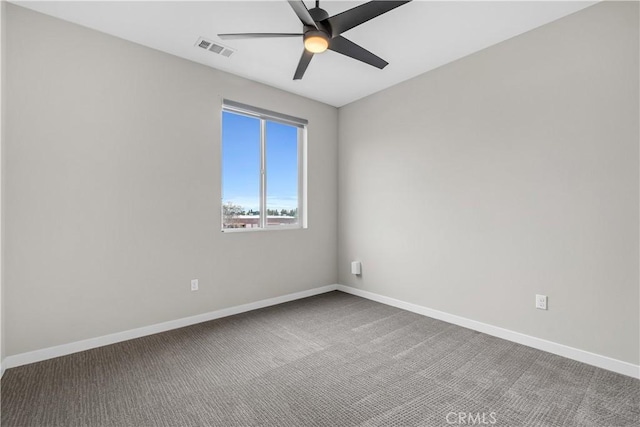 carpeted spare room featuring visible vents, baseboards, and ceiling fan