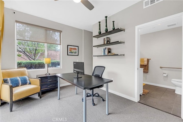 tiled office space with visible vents, carpet flooring, and baseboards