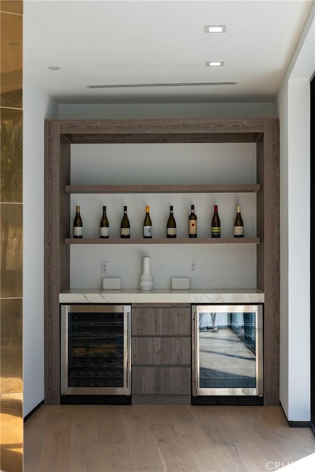 bar featuring a dry bar, beverage cooler, and light wood-style flooring