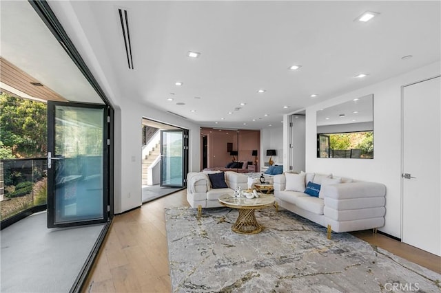 living room featuring stairway, recessed lighting, and light wood finished floors