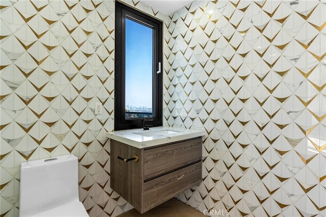 bathroom featuring vanity, tile walls, and toilet