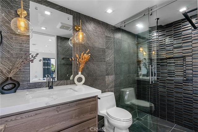 bathroom with vanity, tile walls, toilet, and a shower stall