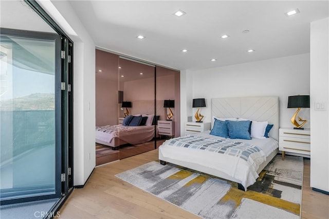 bedroom featuring recessed lighting, light wood-style flooring, and access to outside