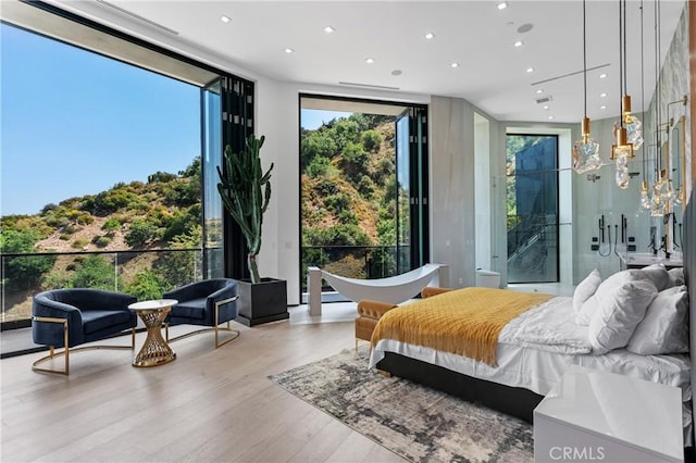 bedroom featuring recessed lighting, wood finished floors, and floor to ceiling windows