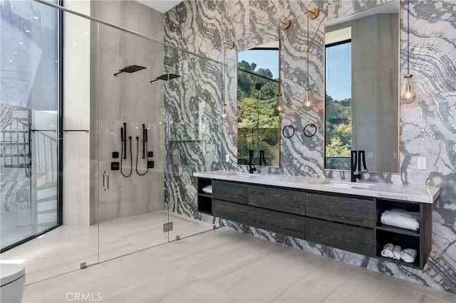 bathroom featuring double vanity, tile walls, and a stall shower