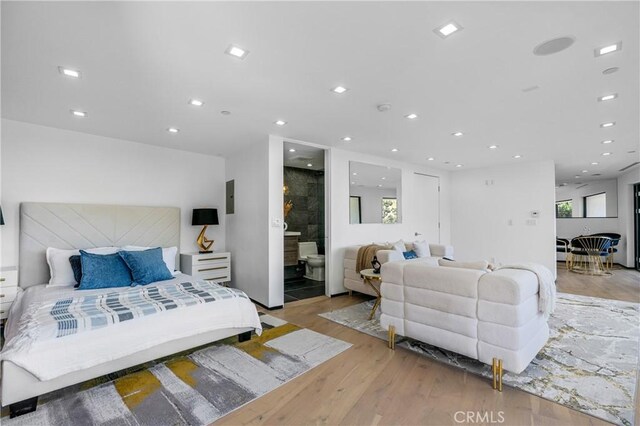 bedroom with electric panel, recessed lighting, and light wood-style flooring