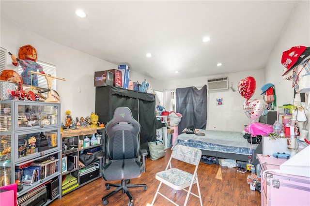 bedroom with recessed lighting, wood finished floors, and a wall mounted air conditioner