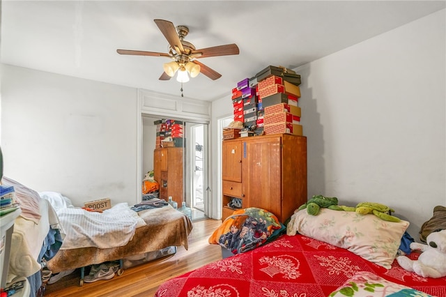 bedroom featuring a ceiling fan, access to exterior, and wood finished floors