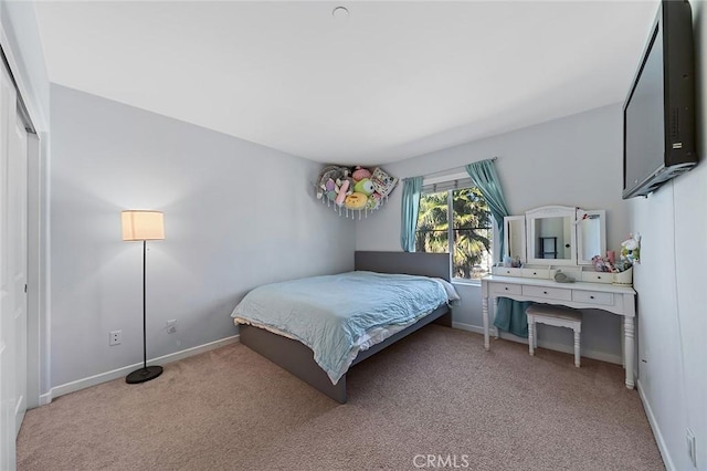 bedroom with light carpet and baseboards