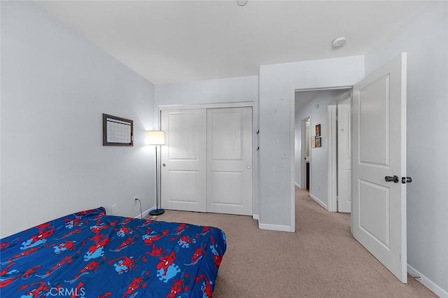 bedroom with carpet, baseboards, and a closet