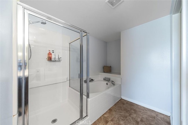 bathroom featuring visible vents, baseboards, a garden tub, and a shower stall