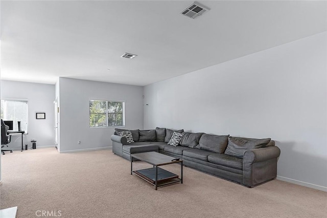 living room featuring light colored carpet, visible vents, and baseboards