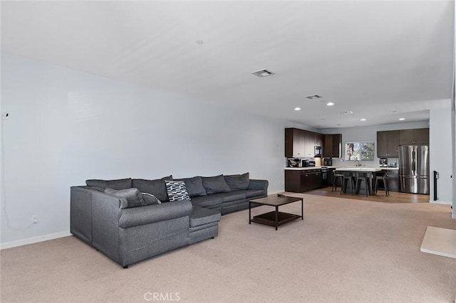 living room featuring recessed lighting, visible vents, baseboards, and light carpet