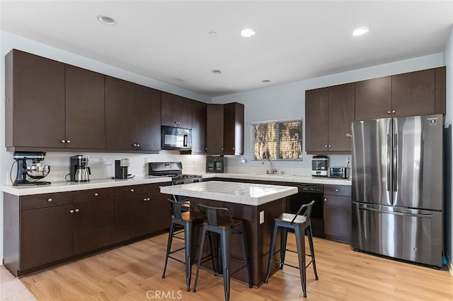 kitchen with tile countertops, black appliances, and dark brown cabinets