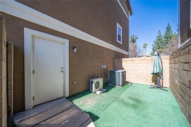 exterior space featuring ac unit, stucco siding, central AC, and fence