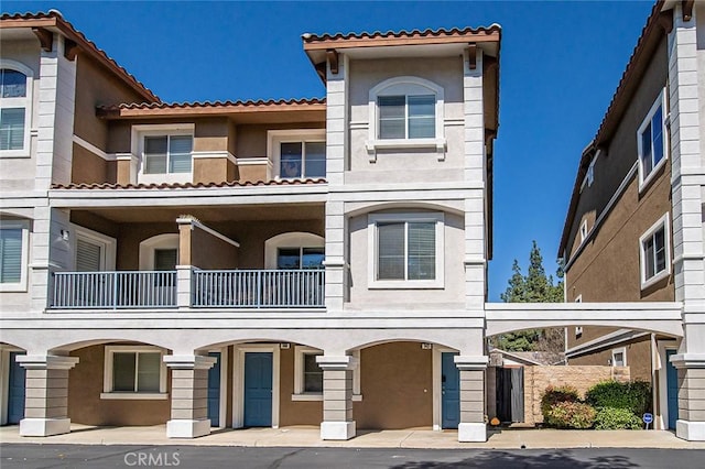 view of property with stucco siding and a balcony