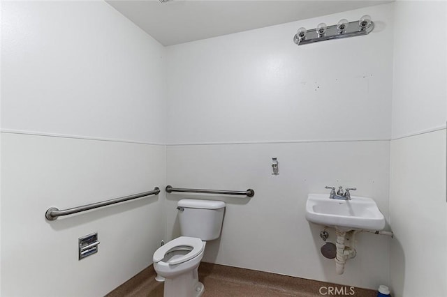 half bathroom featuring toilet and a sink